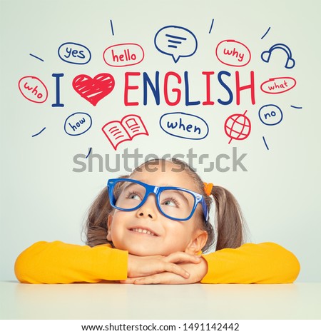 Beautiful cute little girl with eyeglasses looking at the illustrations and words in english above her head. I love english concept.