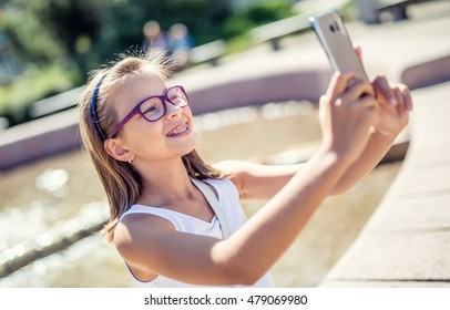 Beautiful Cute Young Girl With Braces And Glasses Laughing For A Selfie.