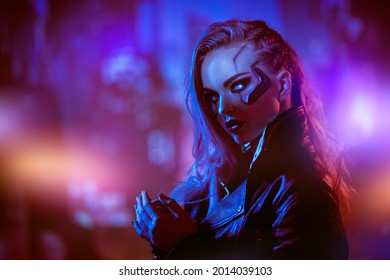 A beautiful cyberpunk girl stands against the backdrop of the night city of the future. Cyberpunk concept. Technology and fashion.
