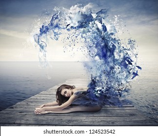 Beautiful dancer with a blue dress that becomes a wave of blue paint - Powered by Shutterstock