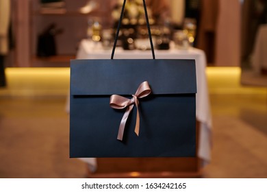 Beautiful Dark Blue Gift Bag With A Pink Bow. Special Evening With Presents. Valentine's Day Or Women's Day. Closeup With Copy Space.