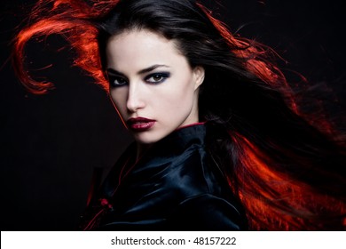 beautiful dark hair woman with hair in motion and red back light