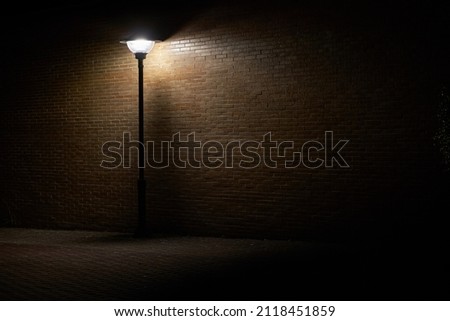 Beautiful and dark lonely street lamp illuminating dark place at night