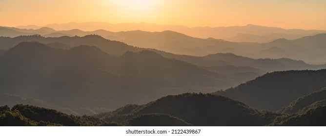 Beautiful dark orange mountain landscape with fog and forest. sunrise and sunset in mountains, Layers of mountain orange rocky hills landscape background. - Shutterstock ID 2122439867