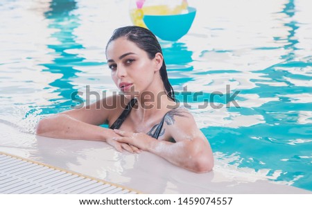 beautiful dark-haired girl in a swimsuit, swimming in the indoor pool of the Spa complex