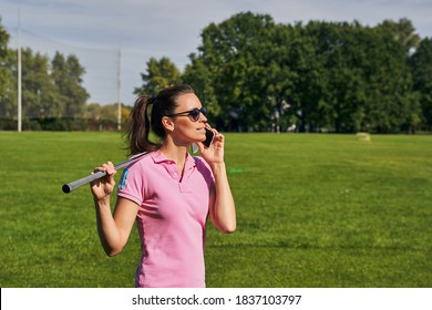 Beautiful dark-haired young Caucasian female golfer in round sunglasses calling on her cellular phone outdoors - Powered by Shutterstock