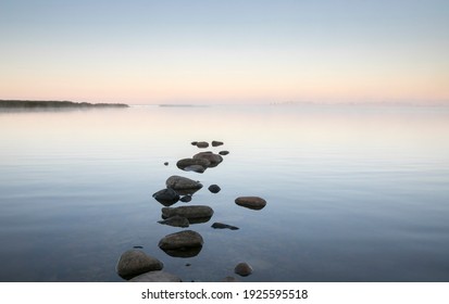 Beautiful dawn seascape with the steaming seawater and stepping stone rocks in the front - Powered by Shutterstock