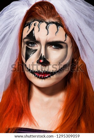 beautiful dead bride with terrible mask painted on her face. Halloween and creative make-up.