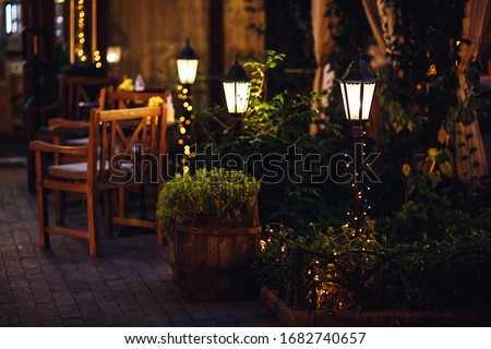 beautiful decor of lanterns and garlands outside in the garden cafe