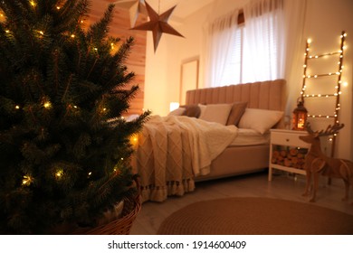 Beautiful Decorated Christmas Tree With Fairy Lights In Bedroom Interior