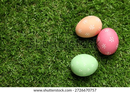 Beautiful decorated Easter eggs on green grass outdoors, flat lay. Space for text