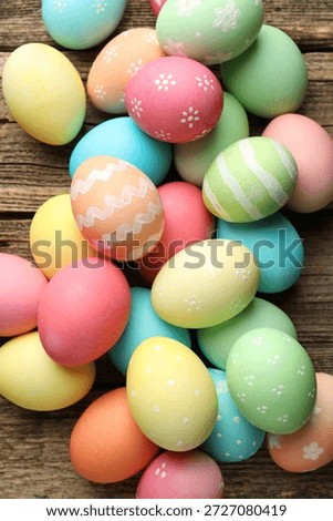 Beautiful decorated Easter eggs on wooden table, flat lay