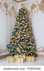 Beautiful Decorated Golden Christmas Tree With Present Boxes In Luxury Classic Interior.