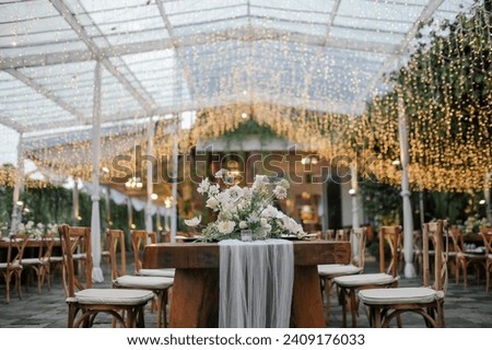 beautiful decoration table setting for family dinner or gathering outdoors. in a sunny day. wedding ceremony, private party. hanging drop light for night time.
