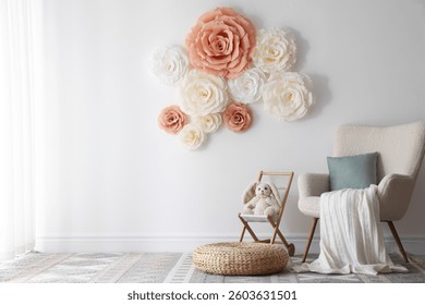Beautiful decorative paper flowers on white wall in child's room
