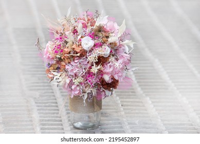 A Beautiful Delicate Bouquet Of Stabilized Flowers, Roses, Dried Flowers, Twigs Of Leaves On A Light Grey Background, Close Up ,selective Focus. Bridal Gift Bouquet