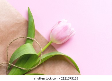 Beautiful delicate pink tulip flower and waxed cord on packaging craft paper background - Powered by Shutterstock