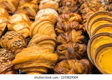 Beautiful Delicious Croissants And Buns, Pastry Cakes. High-calorie Pastries For A Snack. Focus With A Shallow Depth Of Field. Food Background.