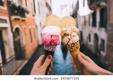 Beautiful and delicious italian gelato in waffle cone in front of streets and bridges of Venice. Ice cream in girls hands on background of water canal and historic buildings of Italy. Travel Europe. - Powered by Shutterstock