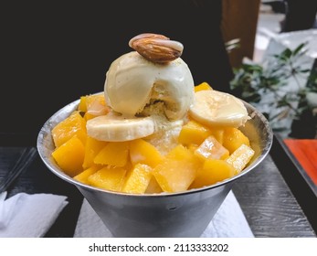 Beautiful and delicious 'Patbingsu' (korean dessert of shaved ice with sweet red beans and fruit) of bananas, mango and almond - Powered by Shutterstock