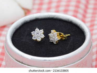 Beautiful Diamond Earrings In Flower Shape Display In Jewelry Box On Red Plaid Cloth Background