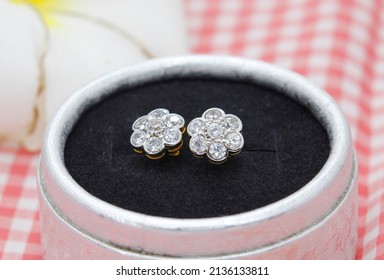 Beautiful Diamond Earrings In Flower Shape Display In Jewelry Box On Plaid Cloth Background