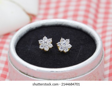 Beautiful Diamond Earrings In Flower Shape Display In Jewelry Box On Red Plaid Cloth Background