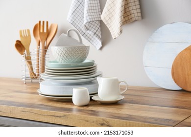 Beautiful dinnerware on kitchen counter near light wall