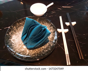 Beautiful dish set There is a green cloth placed on the plate. The side has white and black chopsticks, beautifully placed, elegant, in the restaurant. - Shutterstock ID 1473247049