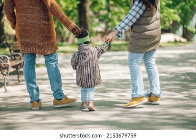 Beautiful Diverse Family Having Fun While Spending Their Free Time In The Park. Happy Multiracial Mother, Father And Daughter Enjoying A Day In The Park. Rear View.