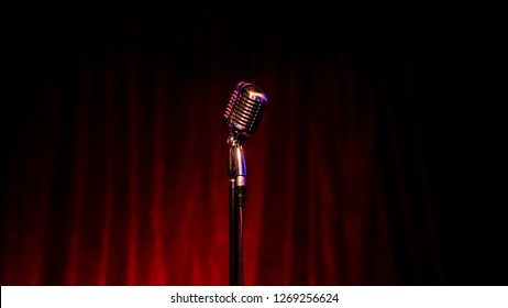 Beautiful And Diverse Subject. Beautiful And Original Retro And Vintage Microphone On The Stand And Tripod On The Background Of Dark Red And Burgundy Curtains And Curtain.