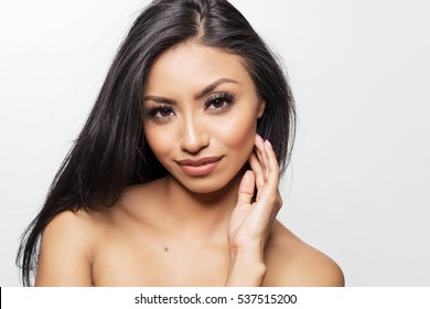 Beautiful Diverse Woman With Gorgeous Face, Dark Luscious Hair And Glowing Skin On Her Bare Shoulders