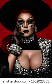 Beautiful Drag Queen In A Black Hat Rhinestones On A Red Background