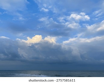 Beautiful dramatic clouds with warm light over calm sea during late afternoon.