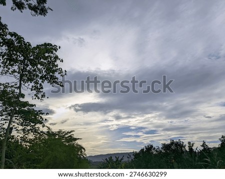 Beautiful dramatic cloudy sky at sunset with layers of grey clouds and a hint of blue sky.