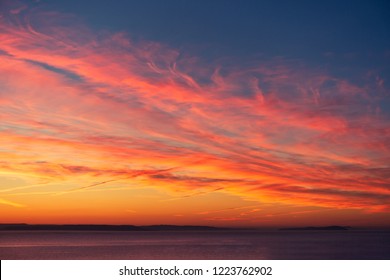 Beautiful, dramatic, fiery sunset, sunrise sky in orange, red, yellow, pink and blue colors.