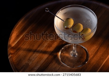 beautiful and dramatic lighting on a dirty martini with 3 olives