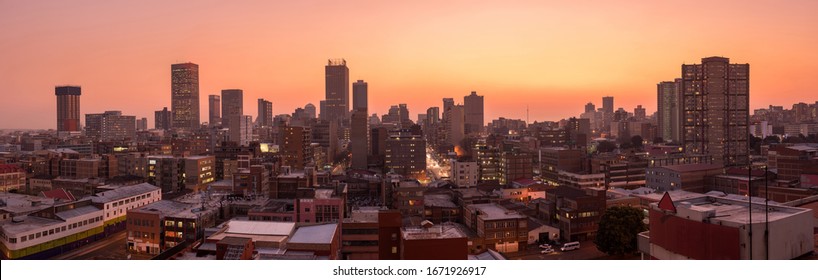 Красивая и впечатляющая панорамная фотография горизонта Йоханнесбурга, сделанная золотым вечером после заката.