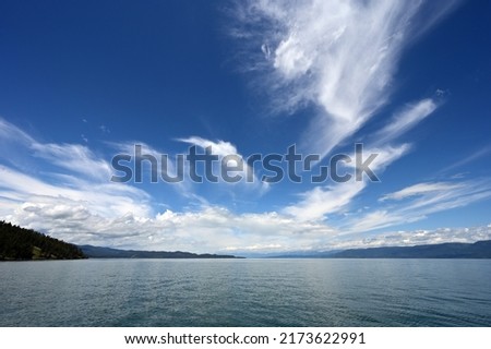 Beautiful dramatic summer cloudscape over Flathead Lake in Montana on calm June day.
