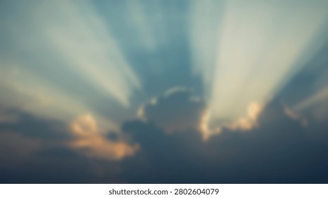 Beautiful dramatic sun rays piercing through dark clouds during a vibrant sunset, creating a celestial and awe-inspiring scene.