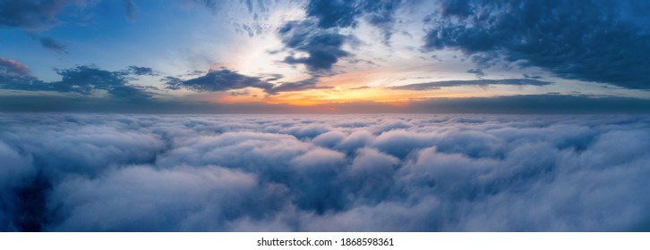 Beautiful Dramatic Sunset Sky Above Fluffy Clouds Early In The Morning From Aerial Drone View.