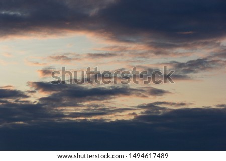 beautiful dramatic sunset sky with clouds highlighted in pink, dark clouds contrast