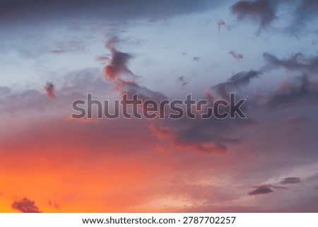 Beautiful dramatic sunset sky with vibrant orange glow and dark twilight clouds over Estonia scenic summer evening atmosphere background. 