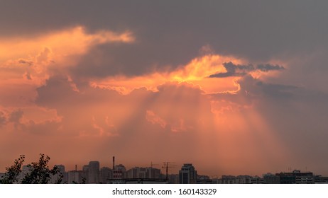 Beautiful dramatic sunset with sun rays through sky hole in cloudscape. 