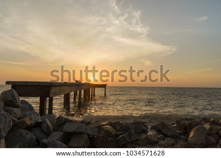Beautiful and dramatic sunset view on Jetty Sungai Burong Beach in Selangor Malaysia. The image contain soft focus, noise and grain