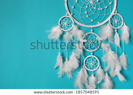 Beautiful dream catcher hanging on light blue background. Space for text