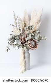 Beautiful Dried Flower Arrangement In A Stylish Pink Vase. In The Flower Bunch Is Pink King Proteas, Palm Frond, Eucalyptus Leaves, Amaranthus And Pampas Grass, Photographed On A White Background.