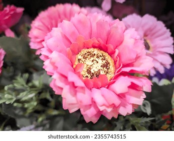 A beautiful dried flower ornament, featuring pink-hued leaves and a central circular element in a vibrant yellow, reminiscent of a sunflower. This exquisite decor piece captures the essence - Powered by Shutterstock