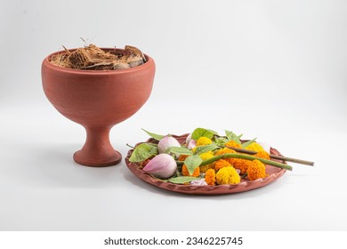 Beautiful durga puja dhunuchi with coconut hask and clay thali with colourful flower isolated on white background.Selective focus with grainy texture on subject.
