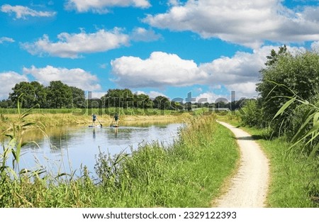 Beautiful dutch rural landscape, river Aa with stand up paddlers, empty riverside hiking and cycle trail - Heeswijk, Noord-Brabant, Netherlands Stock photo © 